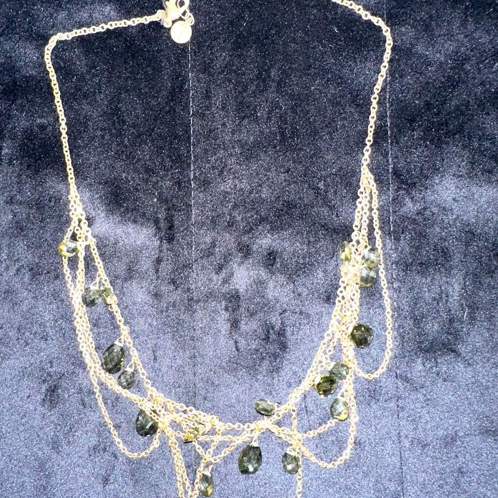Gold tone multi loop necklace with green “peridot” color stones